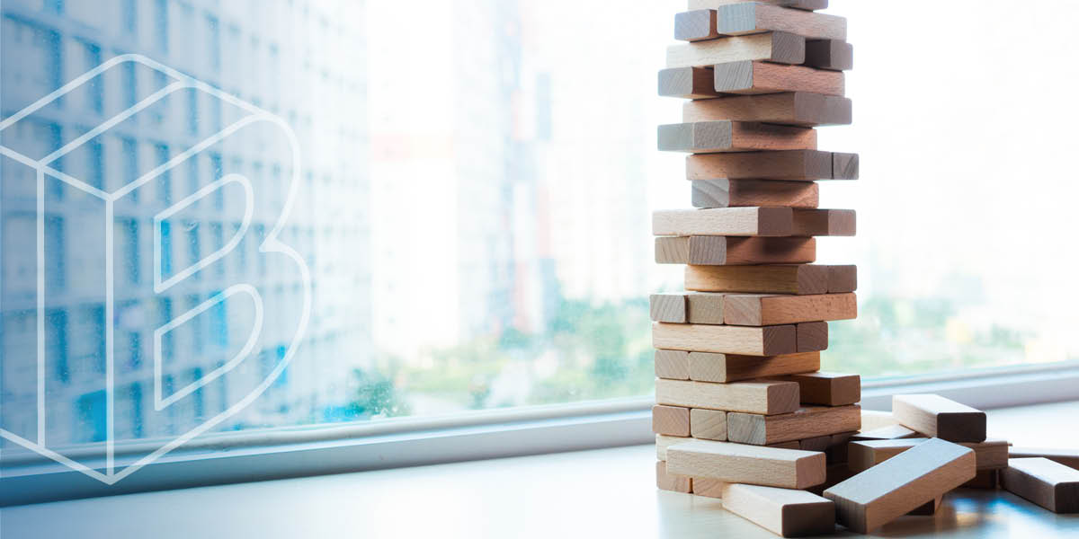 Header image: Jenga-like game of wooden blocks piled on top of each other