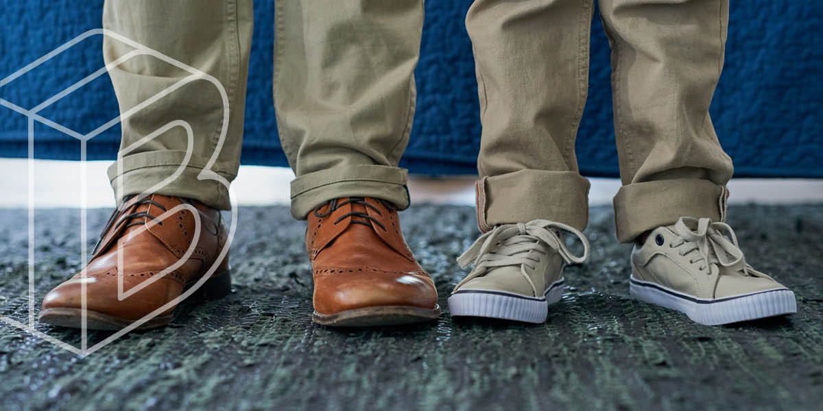 Photo of two people standing on carpet, wearing tan slacks and brown shoes