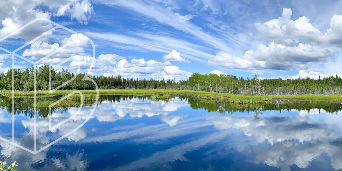 Image: A lake with trees in the background and the water reflecting the sky